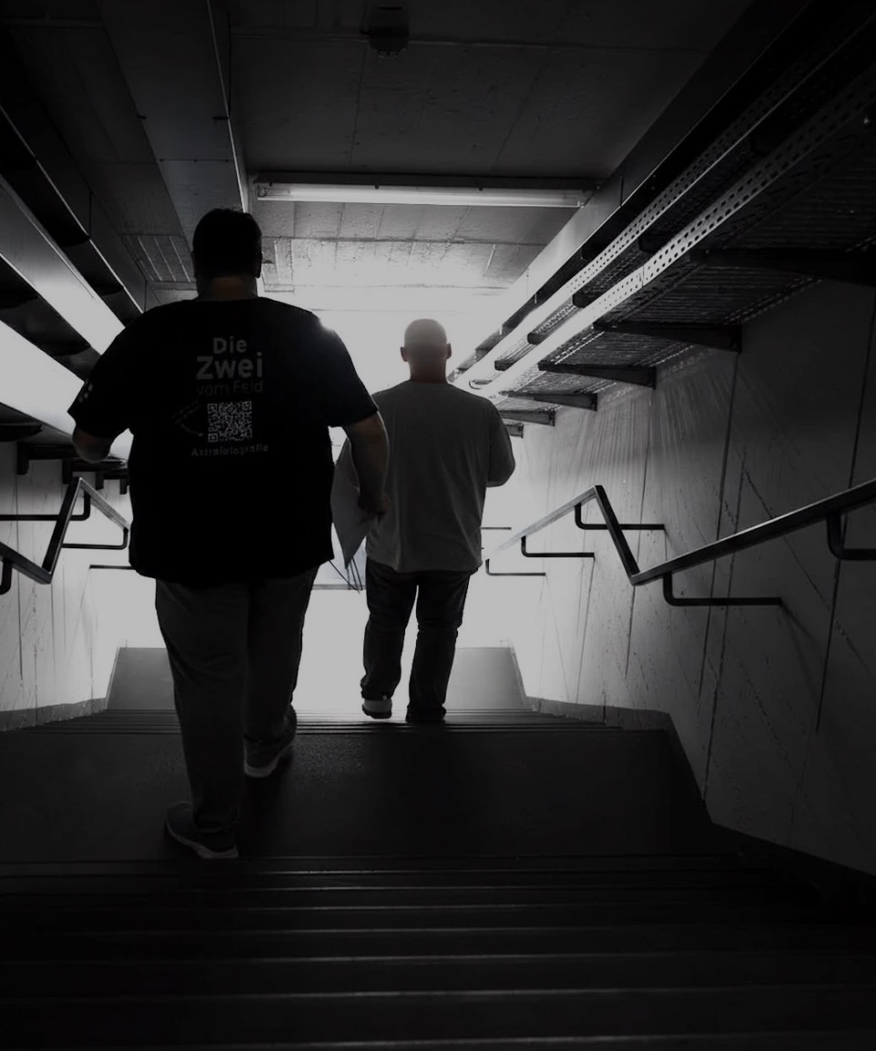 Sven und Tobi von hinten auf einer Treppe ins Licht, auf dem Weg zum Radioteleskop Effelsberg